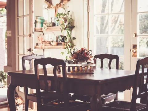 Sala de jantar mobiliada, com mesa de madeira e janelas amplas